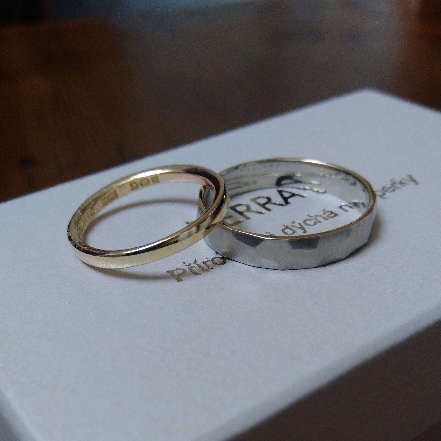 Dámský prsten je jen tenký kroužek ze žlutého zlata a pánský prsten je z bílého zlata a má spilované hrany do tvaru mnohostěnu.