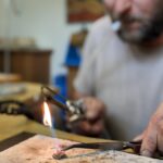 Pomocí pinzety se drží jedna část šperku a ohněm se pak připojí k druhému kusu kovu k sobě